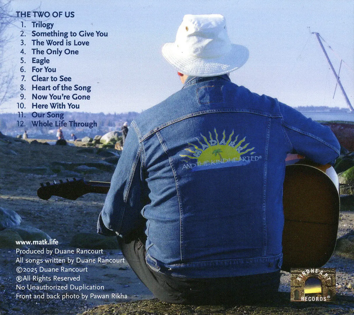 EPSON MFP image A man sitting on top of a rock with his guitar.